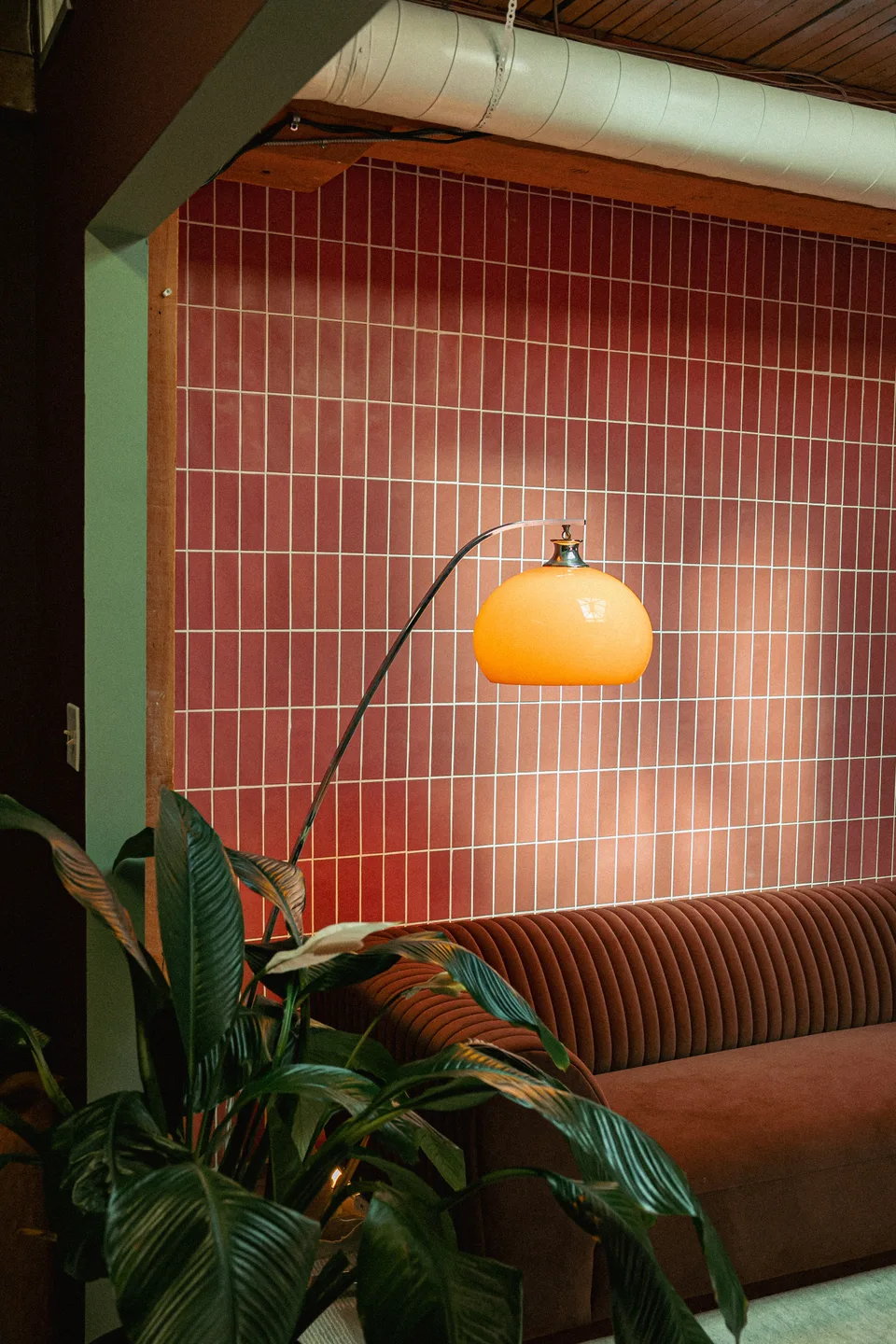 Arc lamp over the velvet banquette in The Tulum Lounge